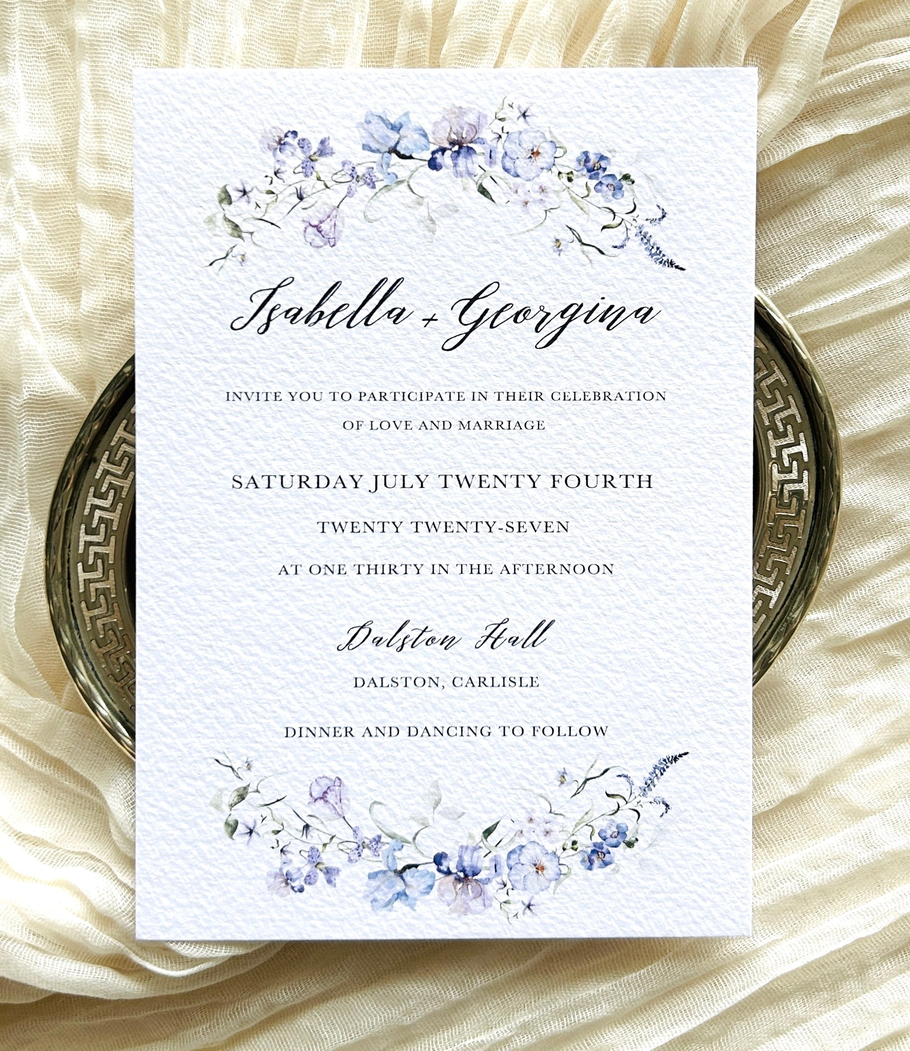 Wedding invitation card with floral design with blue, pink and lilac flowers

